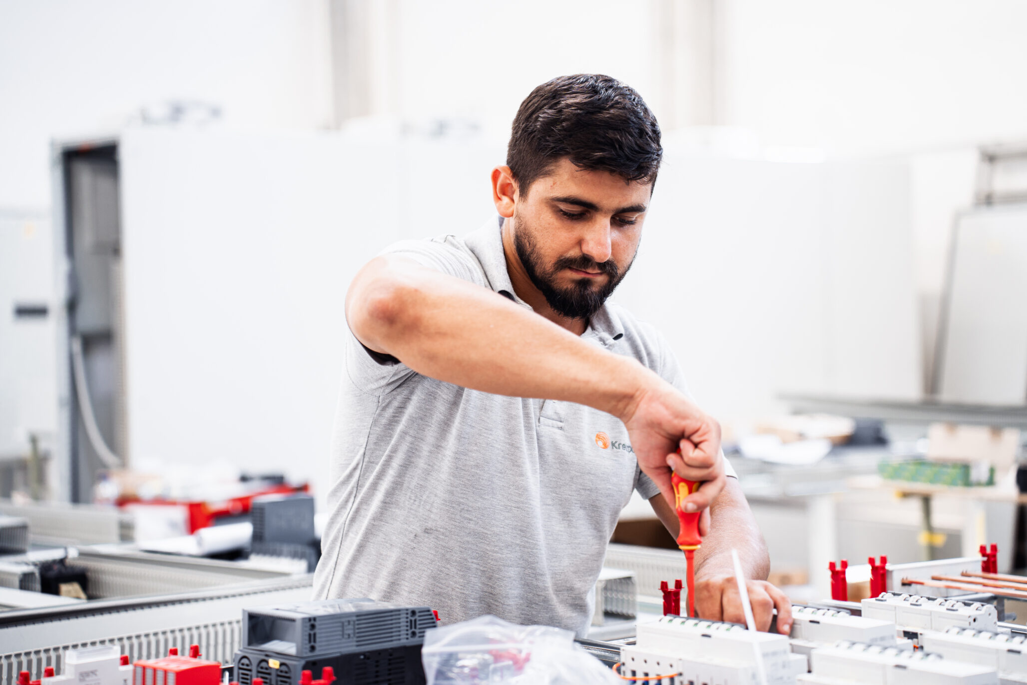 Techniker montiert eine Schaltanlage in der Fertigung – Schaltanlagenbau von Kreutzpointner.